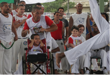 Image de spectateurs regardant quelqu'un danser de la Capoeira
