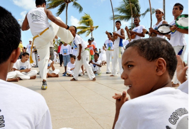 Enfant de dos regardant un spectacle de Capoeira