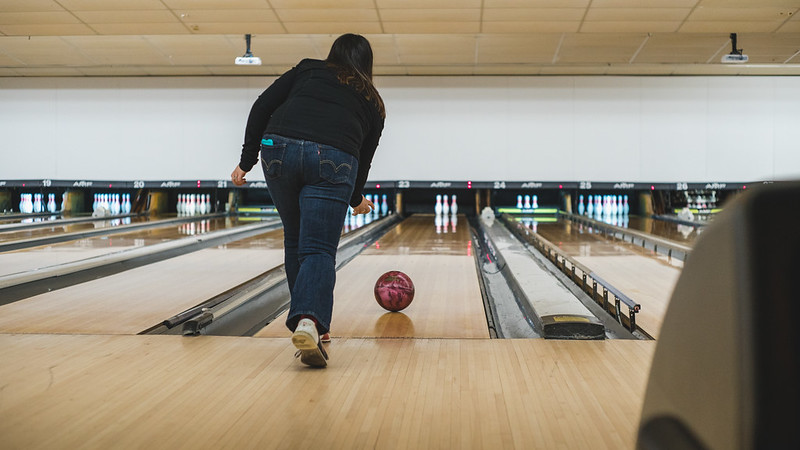 Femme de dos jouant au bowling